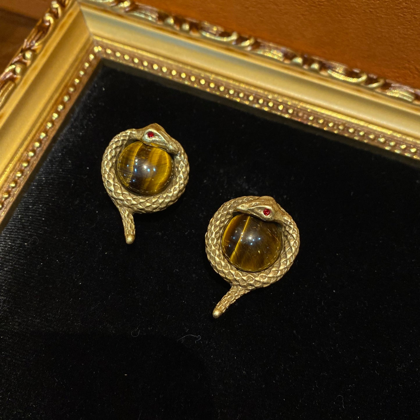 Vintage style designed 18k-gold plated brass in a sanke shape with tiger stone in the middle
