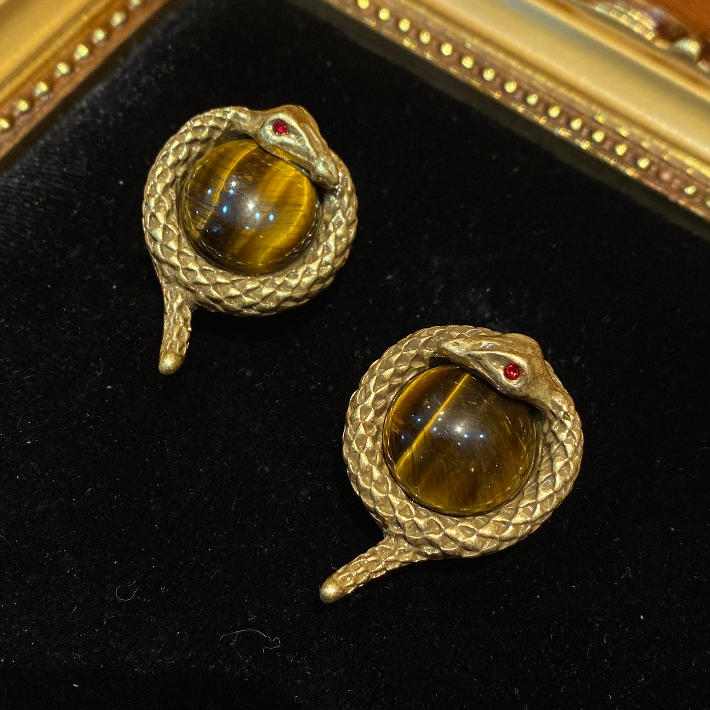 Vintage style designed 18k-gold plated brass in a sanke shape with tiger stone in the middle